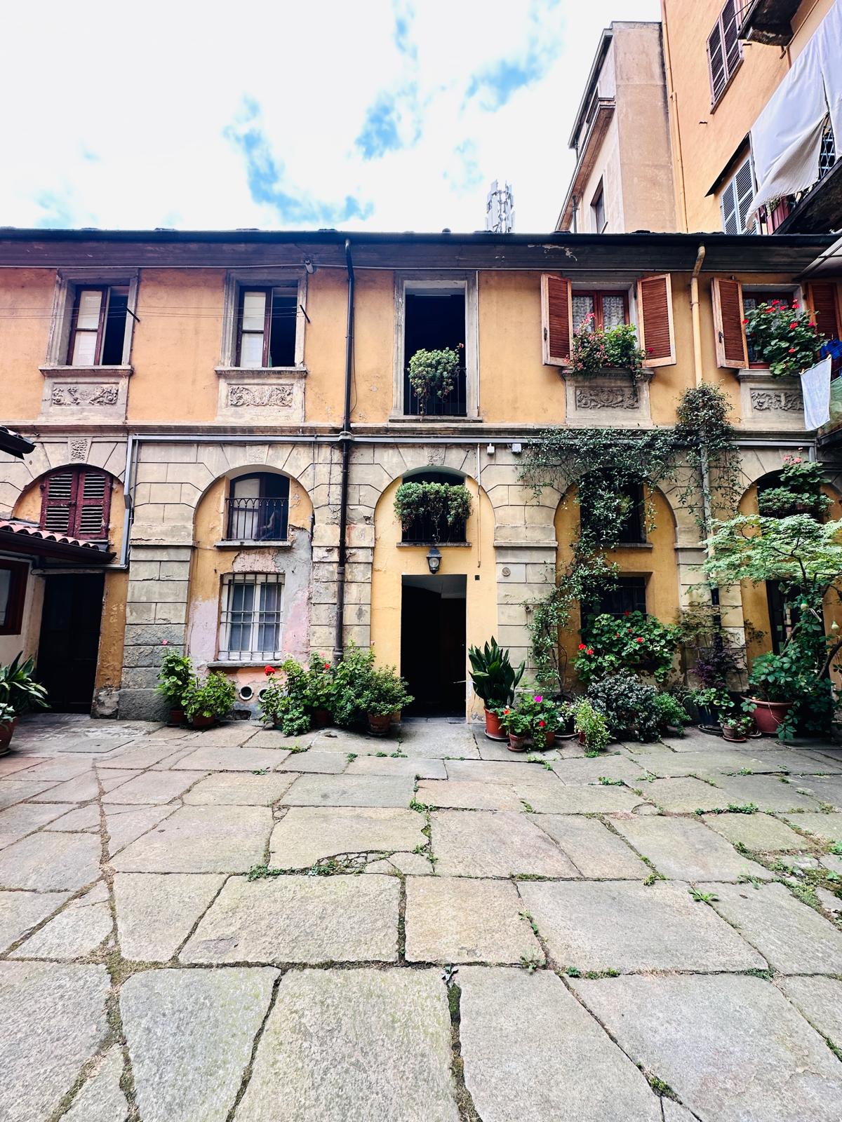 Cortile storico con fiori e porticato