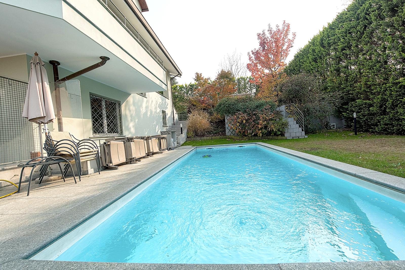 Piscina privata con siepe e giardino
